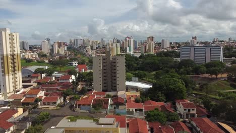 aerial flying over bauru downtown on sunny day, view of vitoria regia park