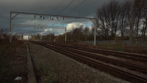 footage of train lines, railway lines, tracks approaching stoke on trent train station in the midlands by the canal, waterside and a50 motorway