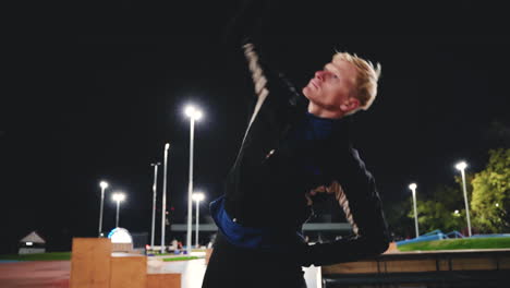 sportive blond man doing stretching exercises before training in the park at night 2