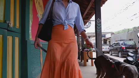 woman walks her dog on colorful charming street in samaipata, bolivia