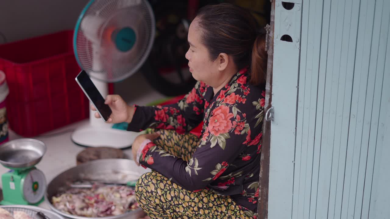 Woman using a smartphone in a fish market