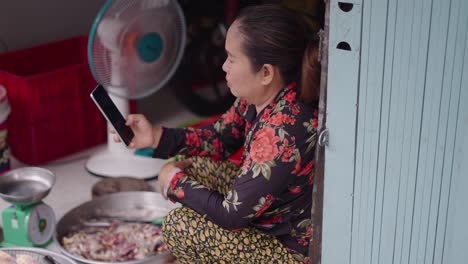 woman using a smartphone in a fish market