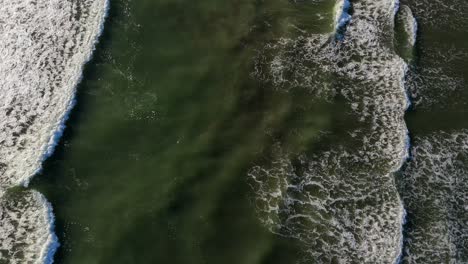 scenic aerial stationary shot of waves in the pacific ocean