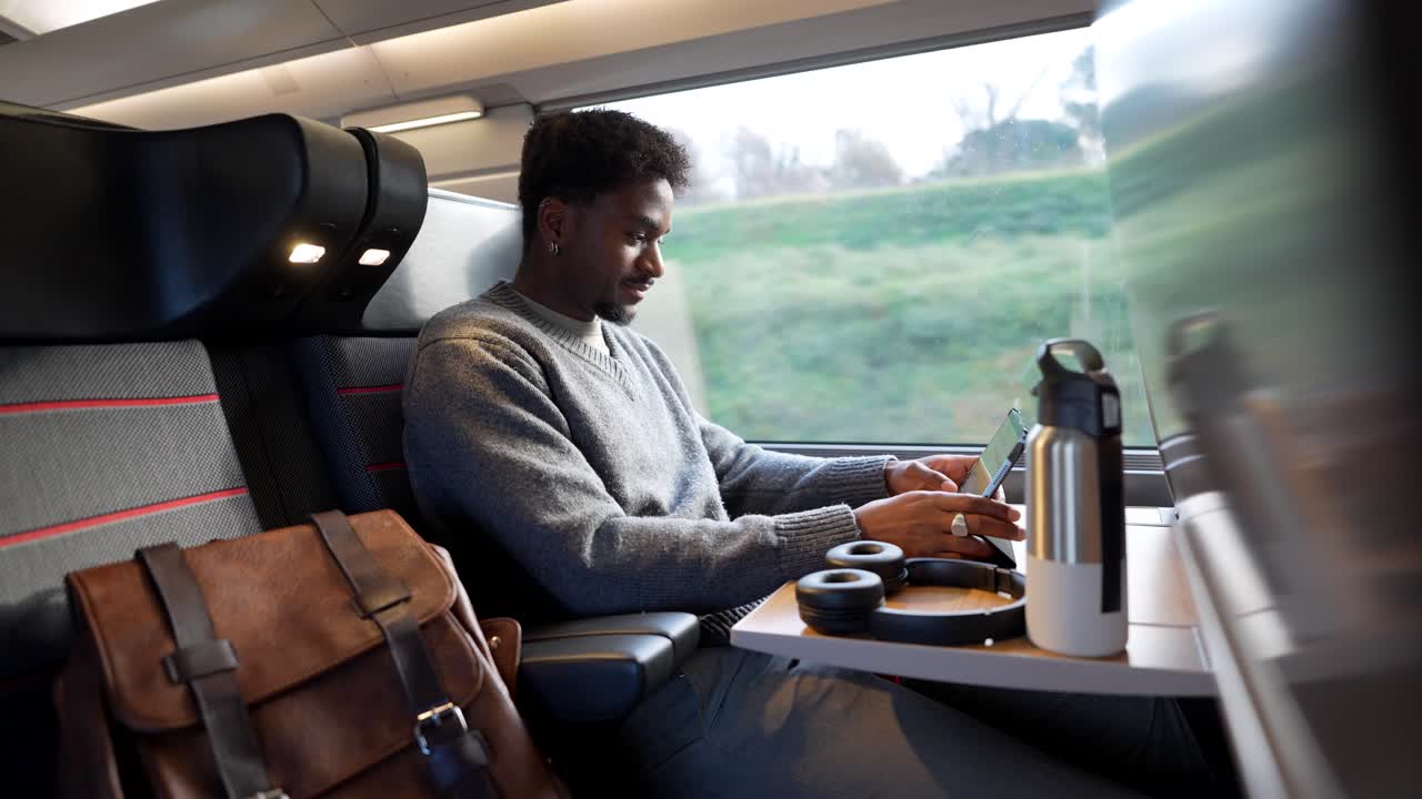 Man working on laptop during train travel