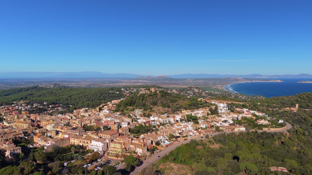 Vista aerea che mostra la città medievale di Begur e il suo castello sulla Costa Brava, affacciati sul Mar Mediterraneo e sulla costa della Catalogna, Spagna, in una giornata di sole