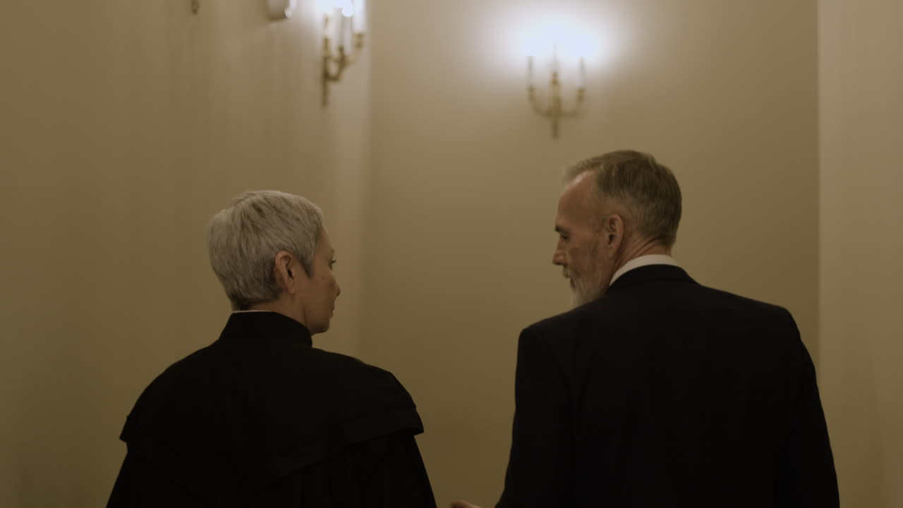 두 사람이 복도 아래로 고 있다.