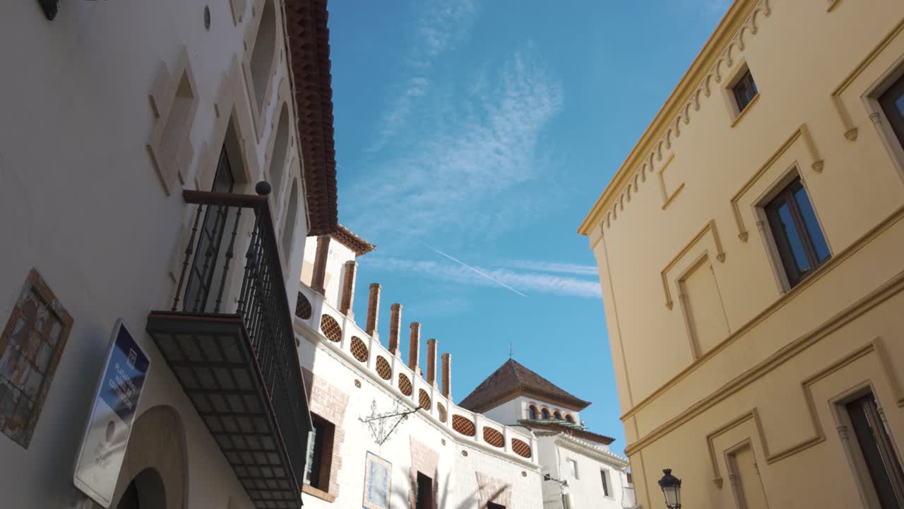 Traditional architecture with balconies and chimneys creating a picturesque scene in sitges, catalonia, under a vibrant blue sky