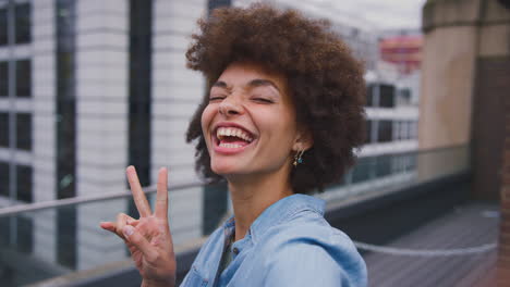 portrait of smiling young businesswoman posing for selfie standing outside modern office