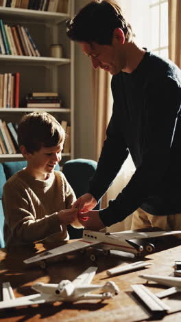 father and son building model airplanes