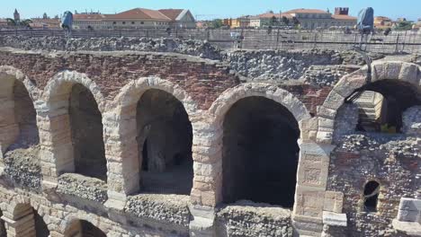 aerial view of arena di verona, italy. the video is made of a drone that rises from behind a wall. a view of the wall and arches.