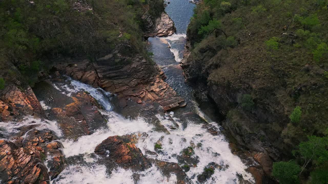 cataratas dos couros en brasil, en el parque nacional de chapada dos veadeiros, mostrando una poderosa cascada en cascada sobre rocas escarpadas, rodeado de exuberante vegetación, drones volando por encima