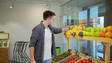 hombre comprando frutas y verduras en una tienda de comestibles