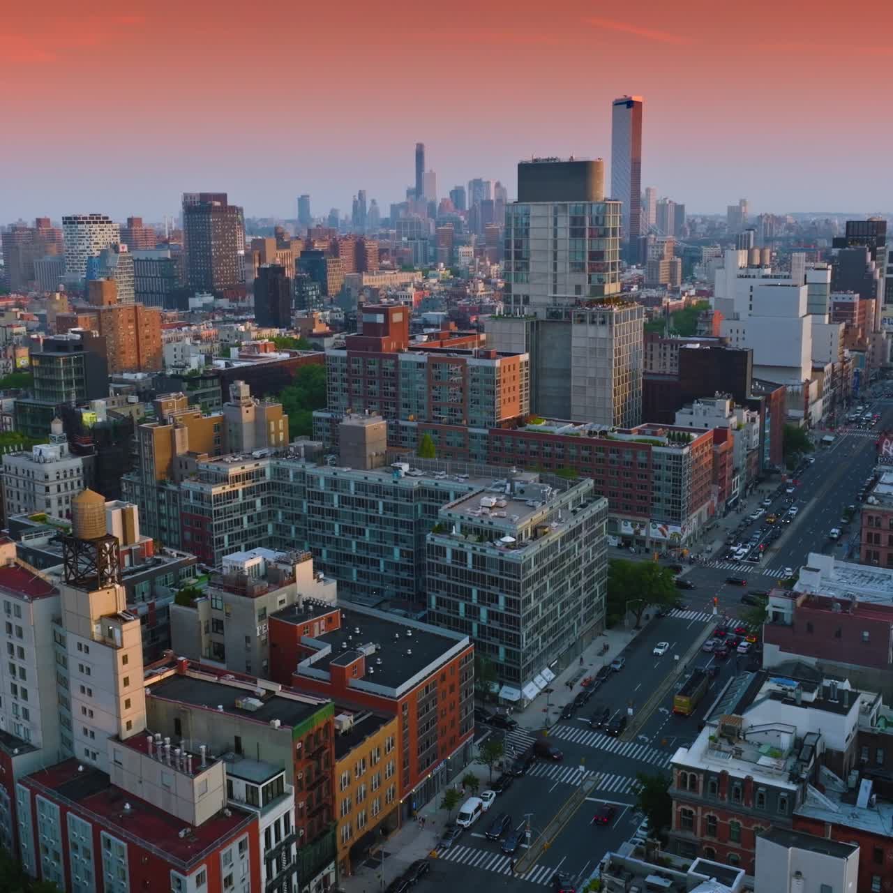 Diverse architecture of beautiful New York. Broad street with cars moving along. Wonderful pink sky background