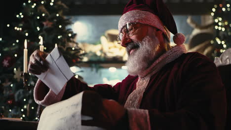 santa claus reading a list by the christmas tree