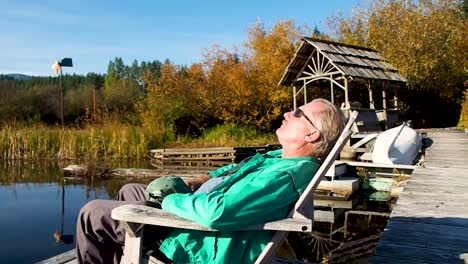 man-sitting-on-dock-at-sunset