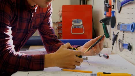 Mechanic-checking-diameter-of-chain-ring-with-measuring-tape-4k