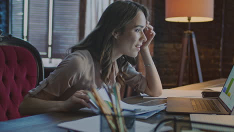 mujer feliz leyendo buenas noticias en la computadora portátil en la oficina de casa