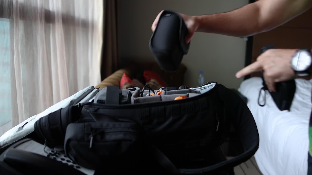 Muž balící brašnu na fotoaparát a zavazadla.