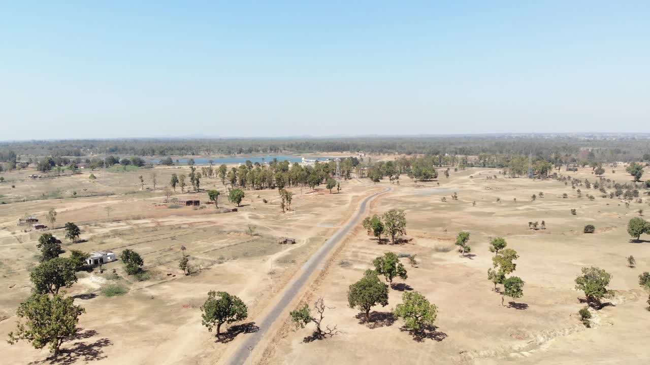 Inquadratura aerea ampia di terra brulla con strada asfaltata nel villaggio di Charu a Chatra, Jharkhand, India.
