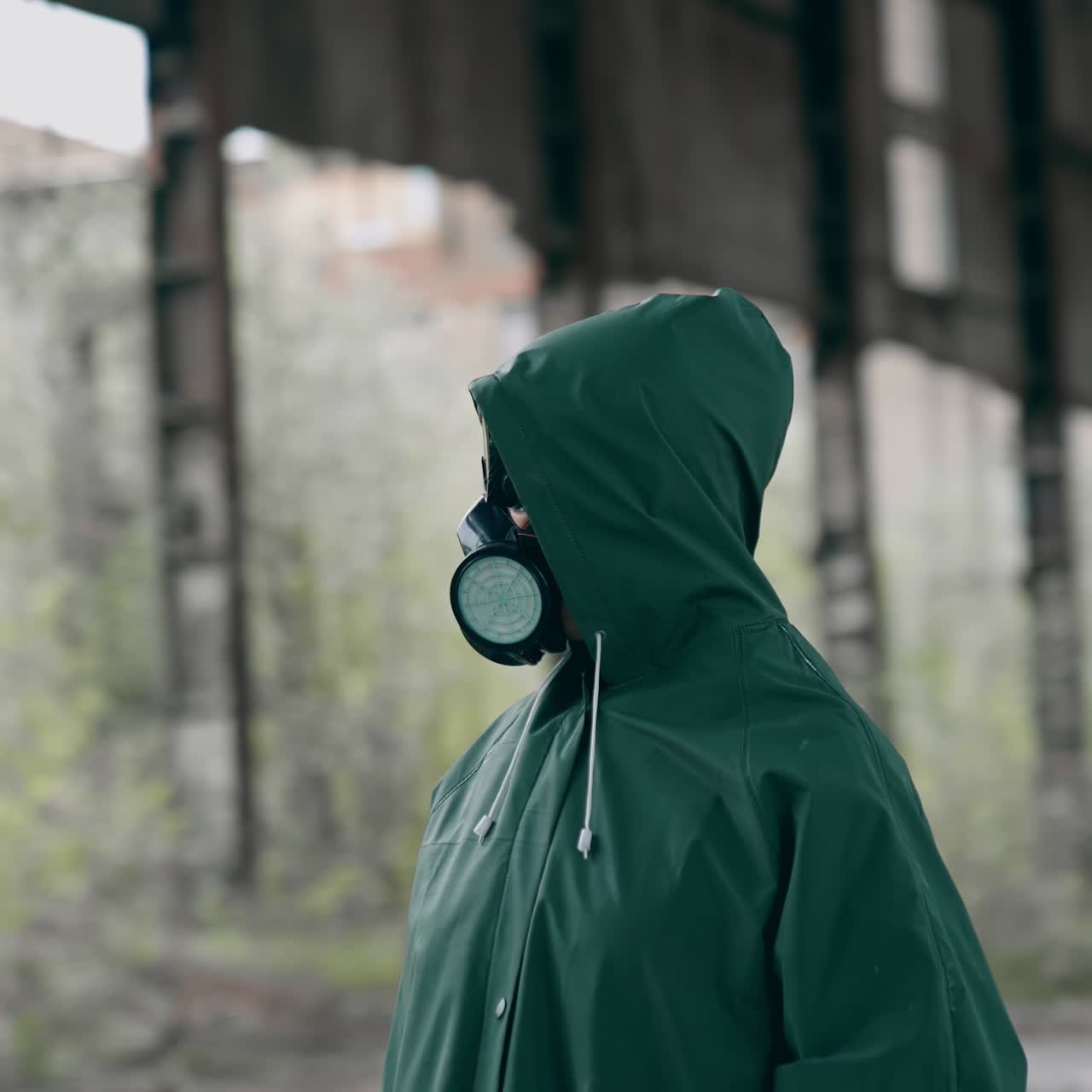 Man in gas mask and protective clothing. Man in gas mask and cloak for chemical protection on abandoned factory