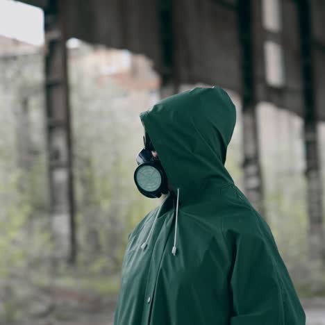man in gas mask and protective clothing. man in gas mask and cloak for chemical protection on abandoned factory