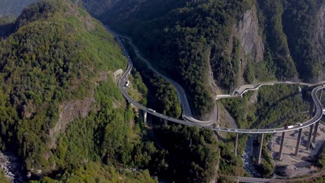 aerial tilt up from a huge and busy bridge to a pristine mountain range