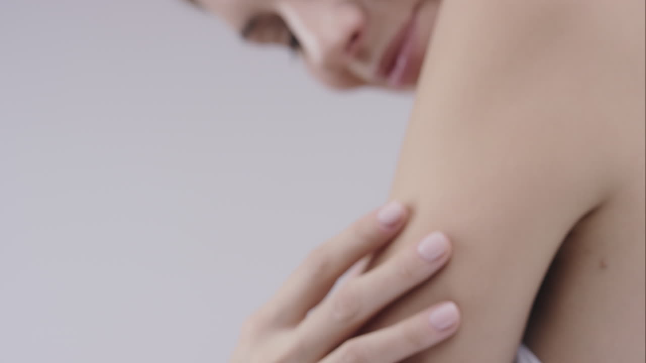 hermosa mujer sana tocando la piel lisa en la cara en cámara lenta para el concepto de cuidado de la piel de belleza en un fondo gris dragón épico rojo