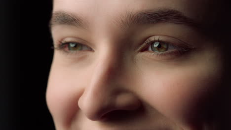 retrato de un rostro femenino feliz sonriendo en un fondo negro. chica feliz en el estudio