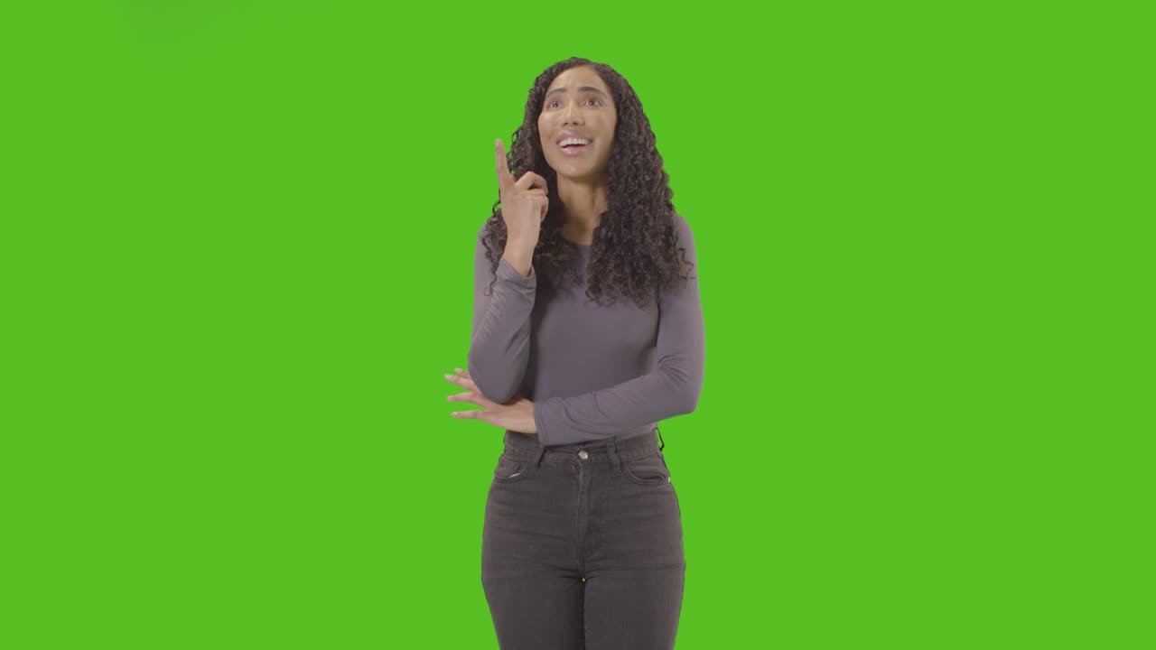 Three Quarter Length Portrait Of Woman Being Inspired By Good Idea Against Green Screen At Camera