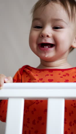 portrait of sweet child playing on the bed. young cute newborn smilling. vertical video