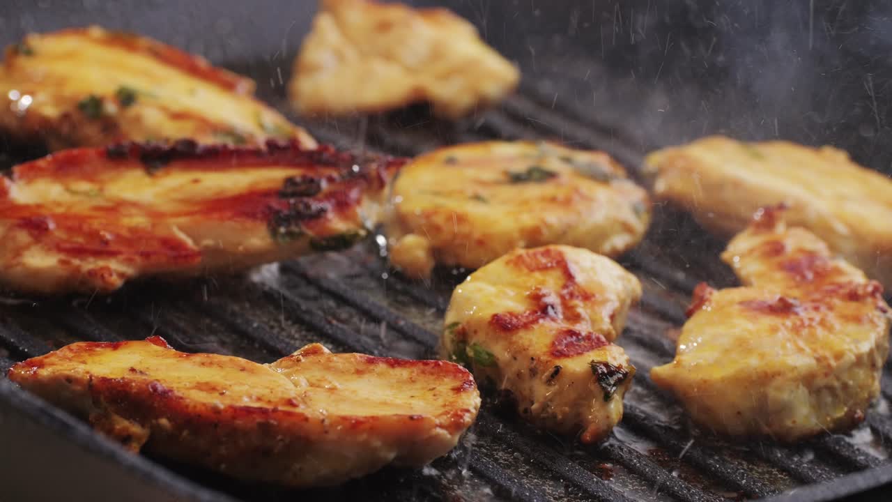 Cooking raw chicken meat in yellow turmeric spice with garlic and greens on grill close-up. Fry chicken slice on frying.pan Grilled chicken, duck, turkey kebab with vegetables.