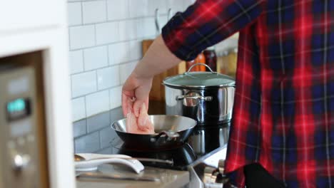 man keeping meat pieces in pan in kitchen 4k