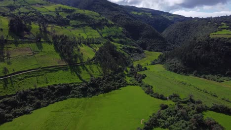 Aerial-Drone-Pushing-In-Over-Green-Mountain-Foothill-Farms-of-the-Pasochoa-volcano,-Puichig,-Cantón-Mejía,-Pichincha-Province,-Ecuador