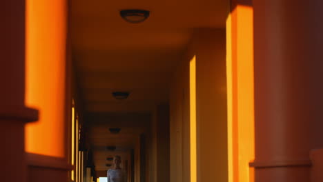 Mother-and-son-with-luggage-in-hotel-corridor