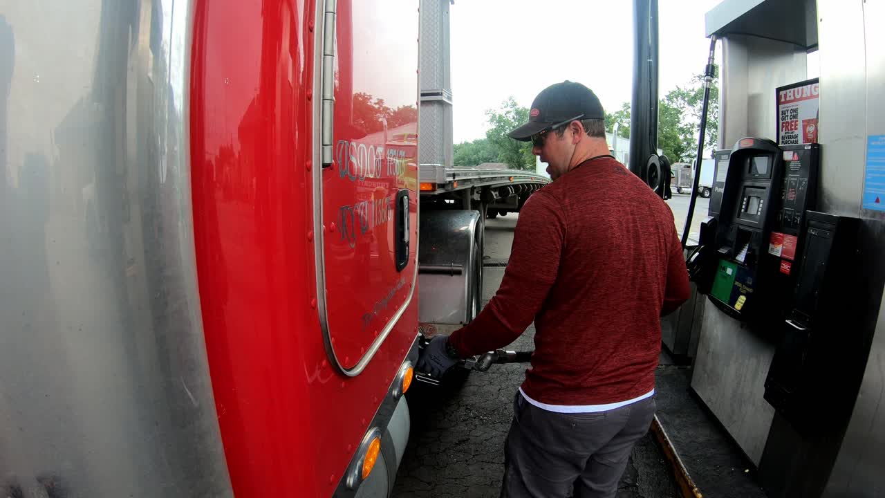 camionero bombea combustible diesel en el tanque del remolque del tractor