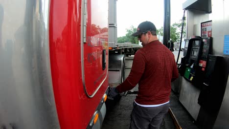 Trucker-pumps-diesel-fuel-into-tank-of-tractor-trailer