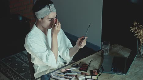 mujer aplicando maquillaje en casa