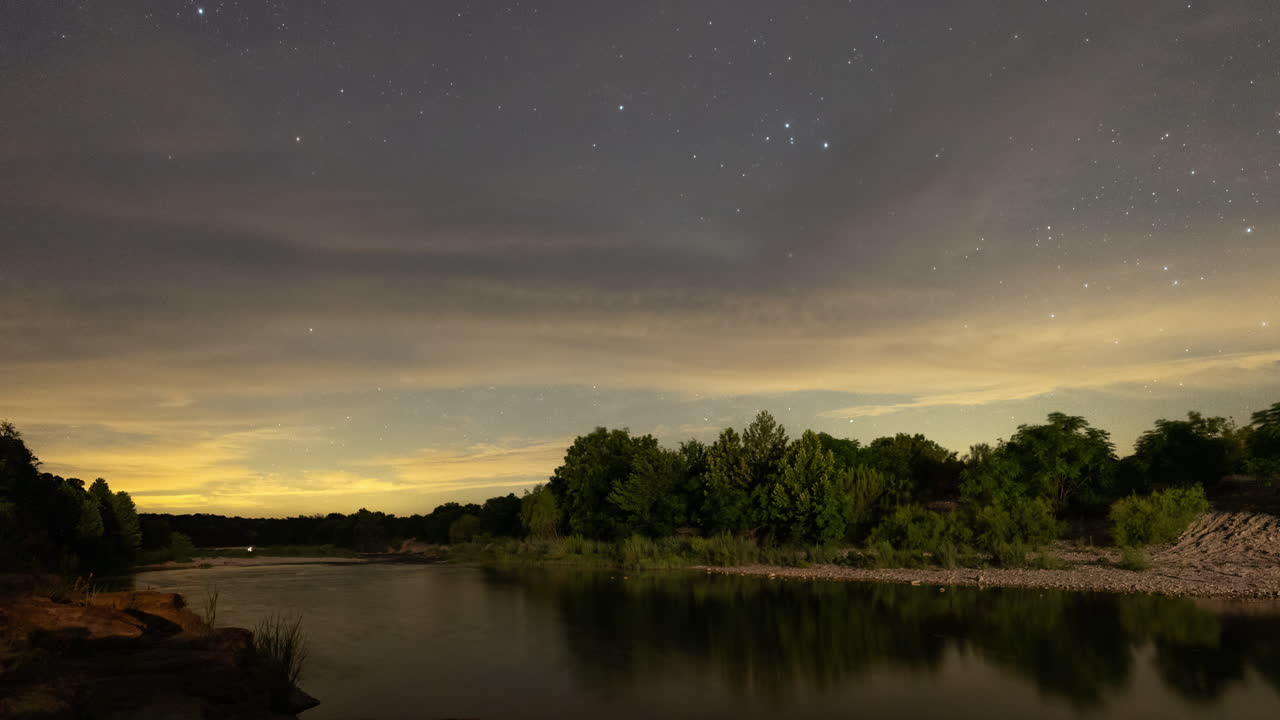 el lapso de tiempo del núcleo de la vía láctea detrás de las nubes y la contaminación lumínica sobre el río llano fuera de mason, texas en el país de las colinas de texas