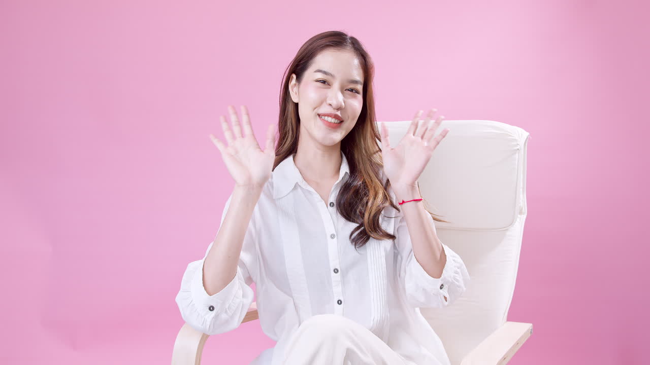 쾌활한 예쁜 소녀가 앉아서 실내에서 카메라를 보고 웃고 있습니다.