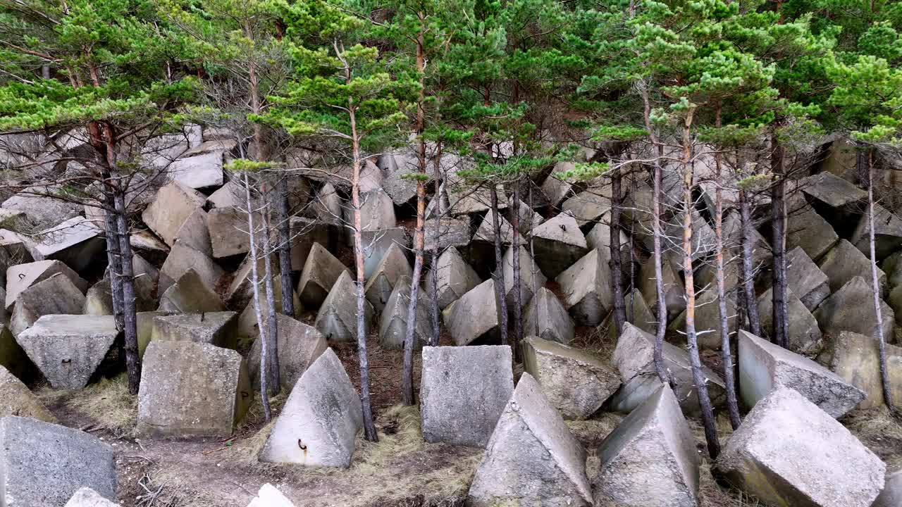 Closeup drone fly grey concrete stones for construction at dam river forest aerial view green trees, industry