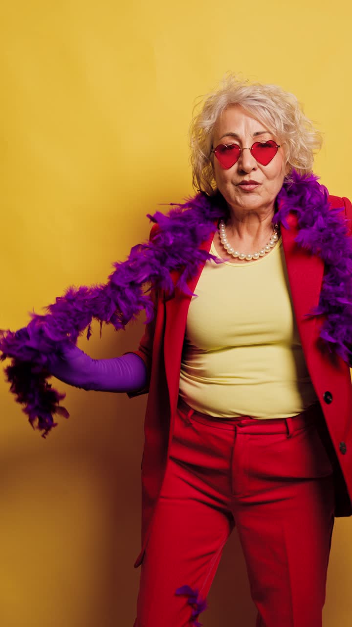 Stylish Senior Woman Dancing Playfully with Purple Feather Boa