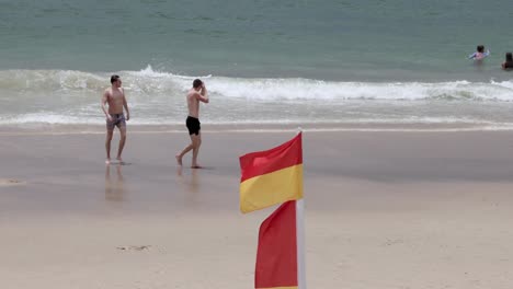 two people running along a sandy beach