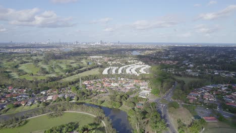 aerial view of the town of robina on a sunny day in gold coast, queensland with coastal skyline in distant background