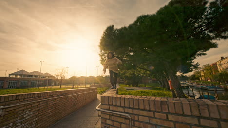 person parkour jumping and sitting on brick wall at sunset