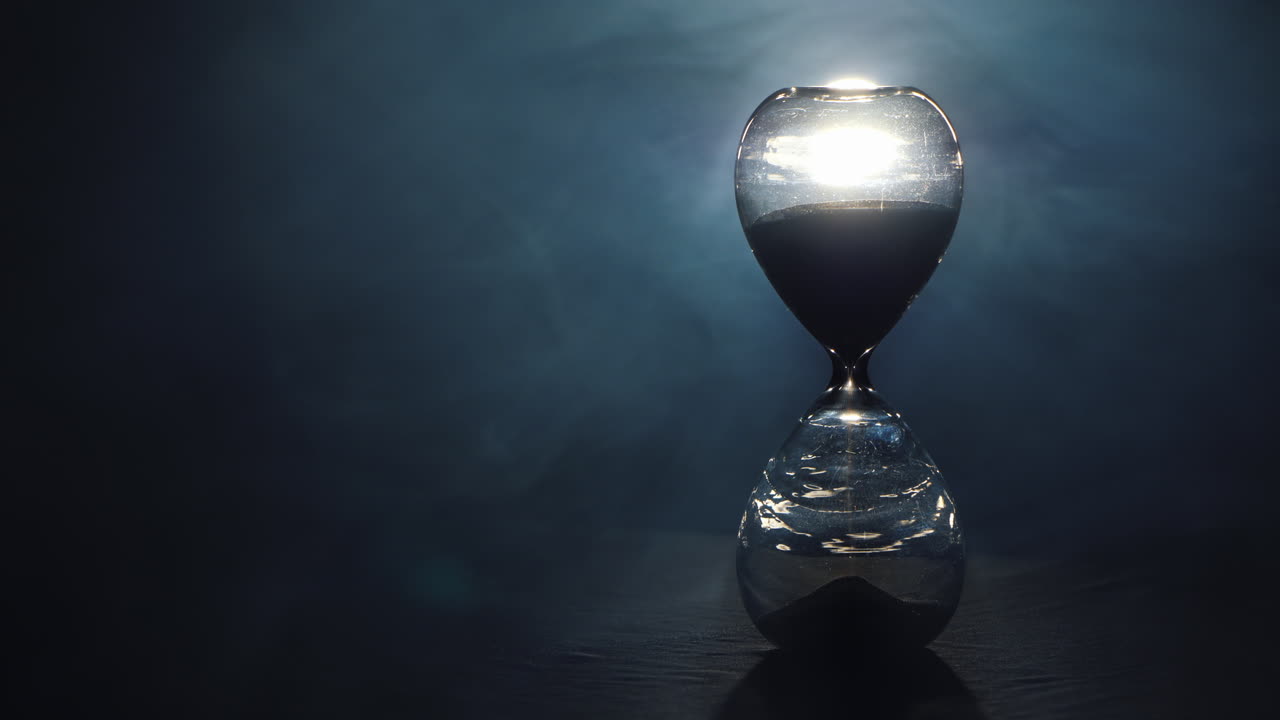 reloj de arena sobre un fondo negro con niebla girando 2