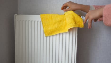 cleaning a radiator with a yellow cloth