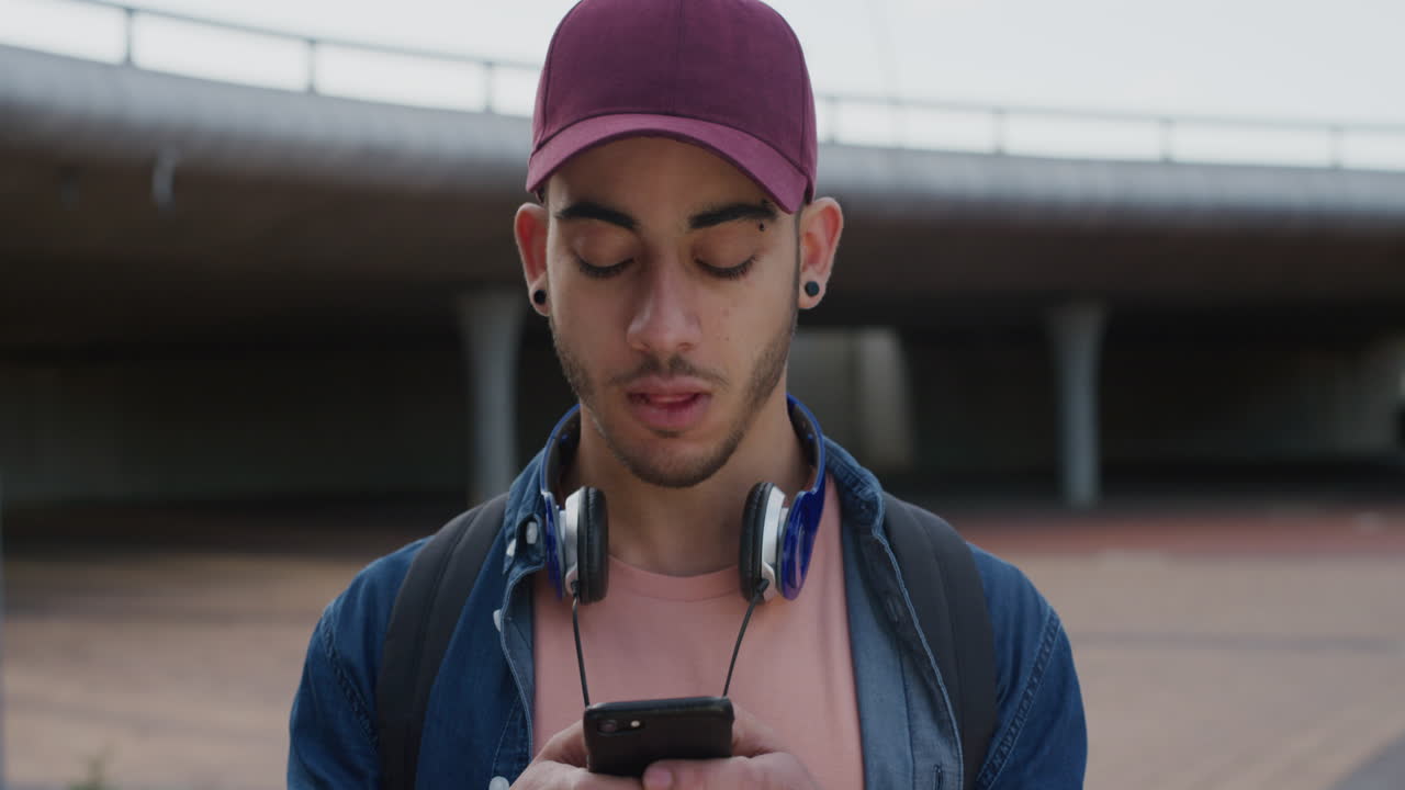 portrait young mixed race man student using smartphone enjoying browsing messages texting social media on mobile phone communication app smiling cheerful
