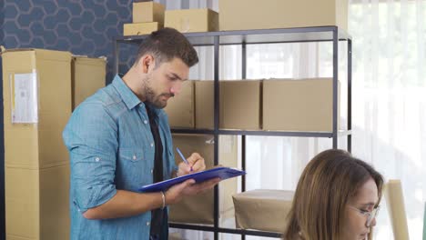 la pareja de ventas y marketing en línea analiza y prepara pedidos de productos en sus oficinas.