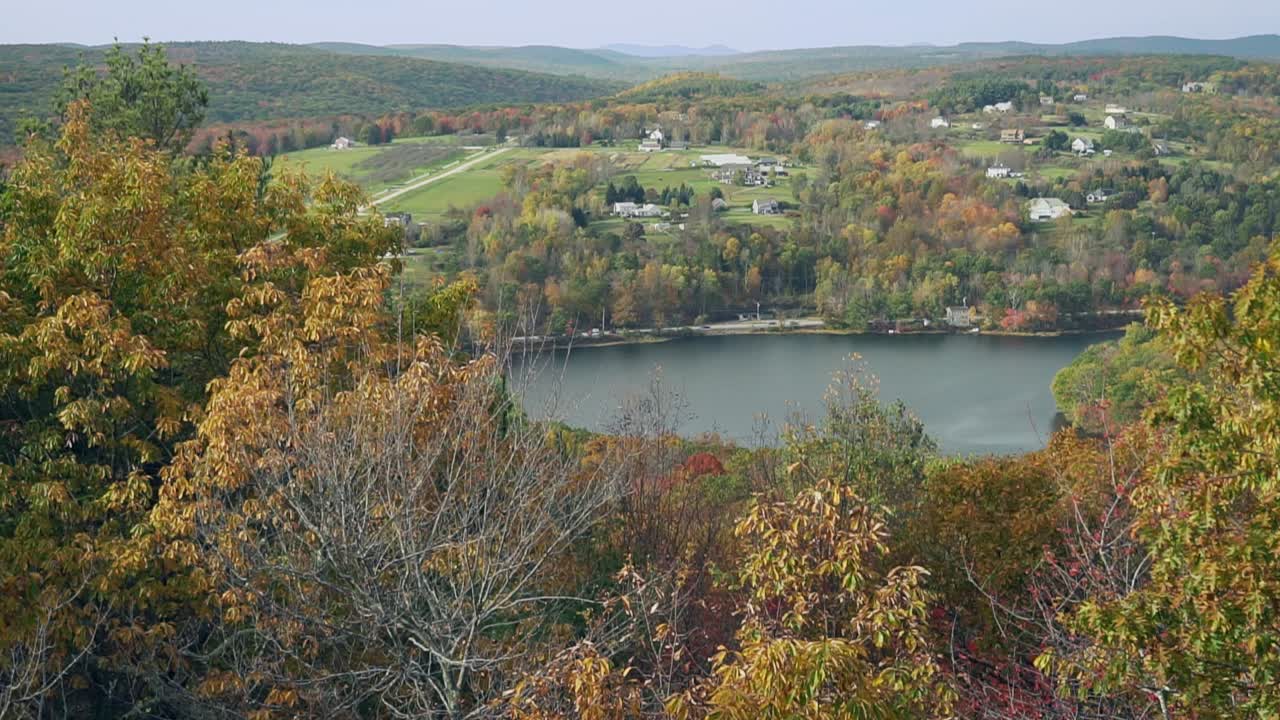 a lake with fall colors overlooking a beautiful valley and distant mountains