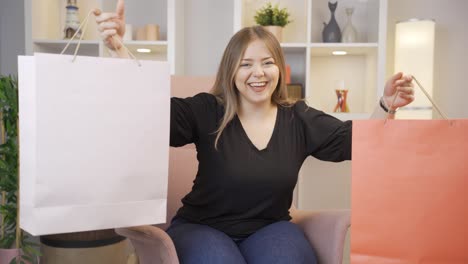 mujer joven mirando a la cámara con bolsas de compras.